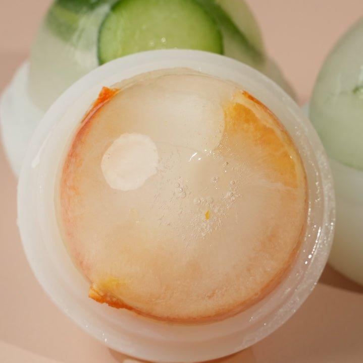 Close-up of Face Junkie ice facial globes infused with natural ingredients like peach and cucumber. These skincare tools provide cooling therapy to reduce puffiness, soothe inflammation, and enhance circulation for a radiant complexion. Face Junkie promotes holistic beauty, combining natural elements with high-performance skincare for a refreshing and rejuvenating self-care routine.