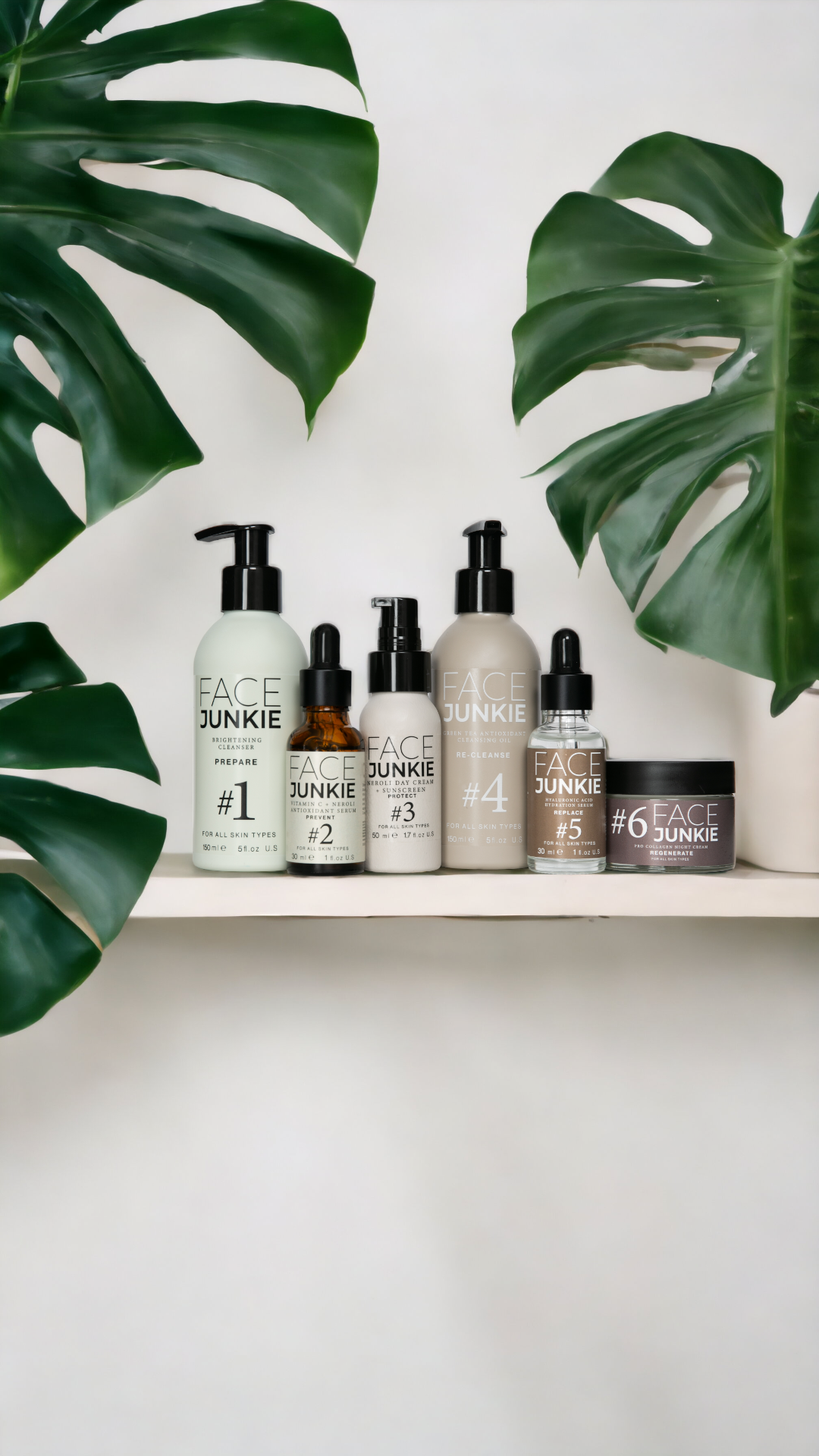 An arranged product shot of the Hero Collection, featuring a lineup of skincare essentials surrounded by greenery.